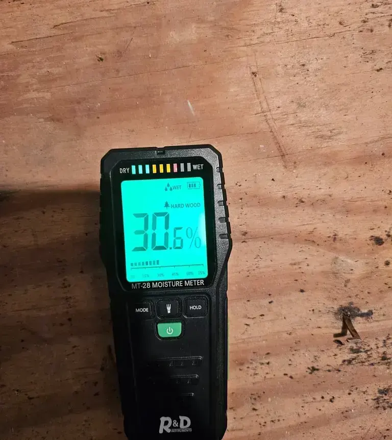 Moisture meter reading a wet subfloor during a water damage inspection in Brentwood, TN
