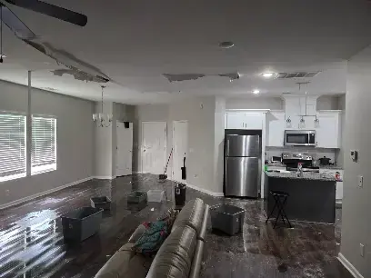 Open kitchen and living room with water across the floor in Brentwood, TN